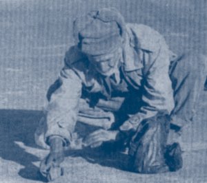 An starving old man collects rice from street in Kabul